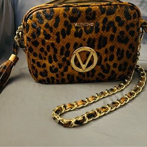 Made in Italy leather, this camera bag is styled with a metallic chain